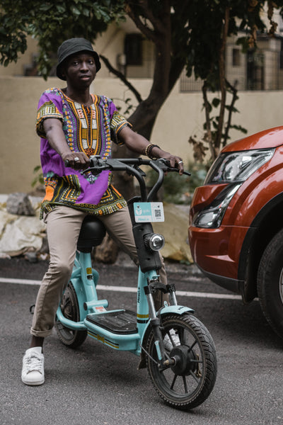 A man wearing a Dashiki on his scooter